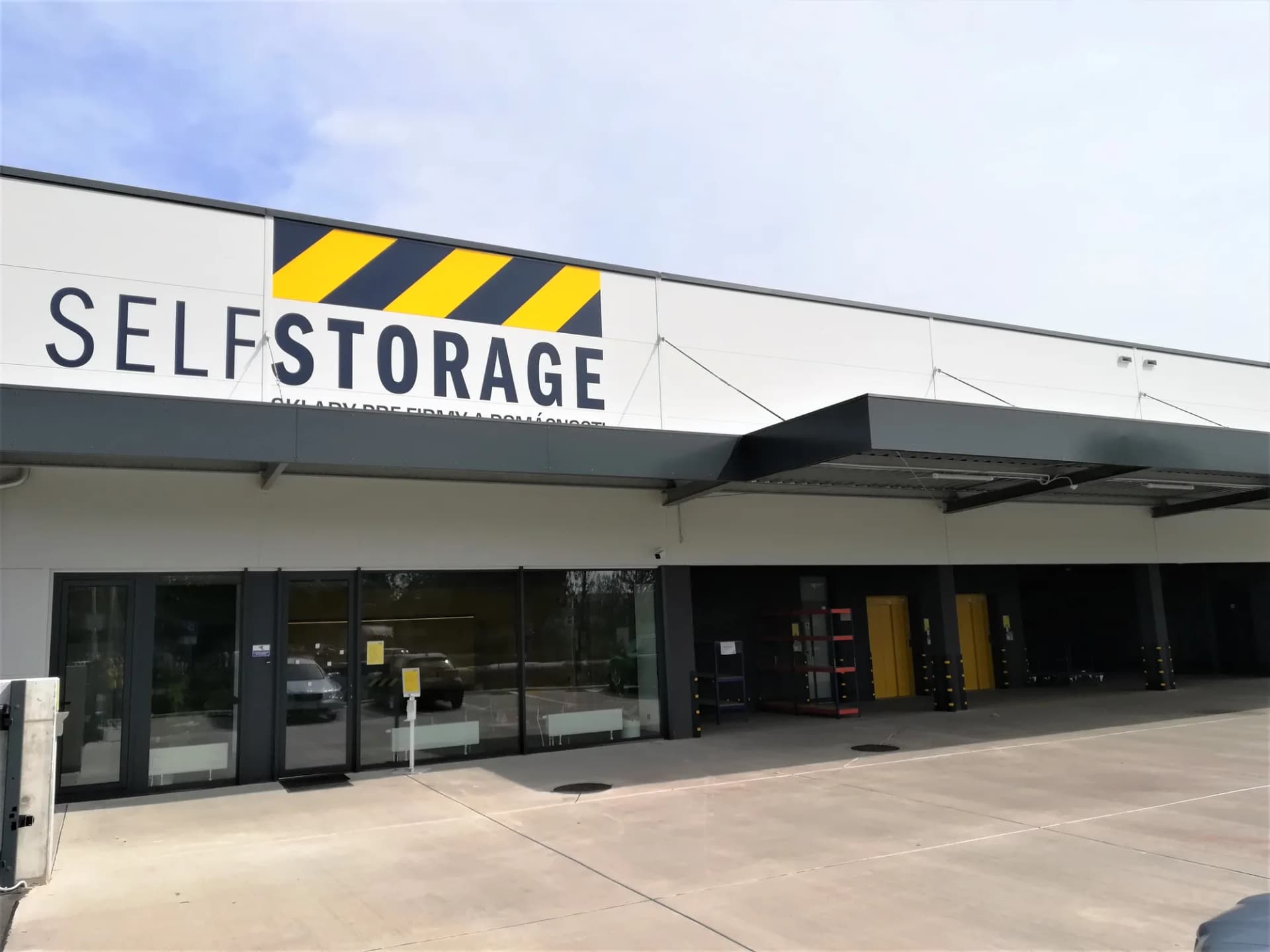 Budova SELF STORAGE so žltočiernym nápisom a sklady pre firmy a domácnosti